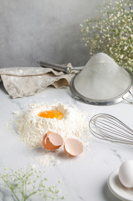 Uovo rotto su farina, in un laboratorio di pasticceria